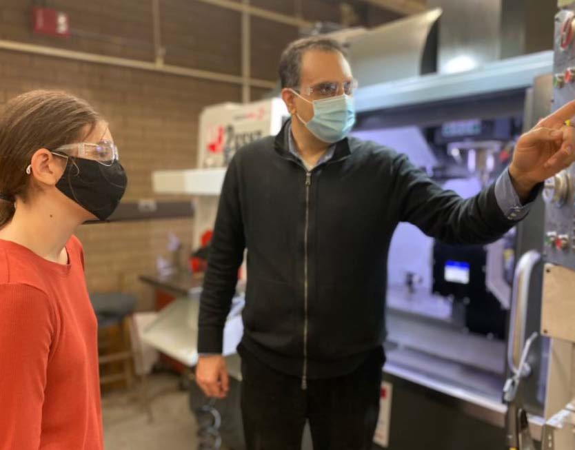 Dr. Siamak Farhad (right) is training UA student, Michala Dauterman (left), on a CNC machine.